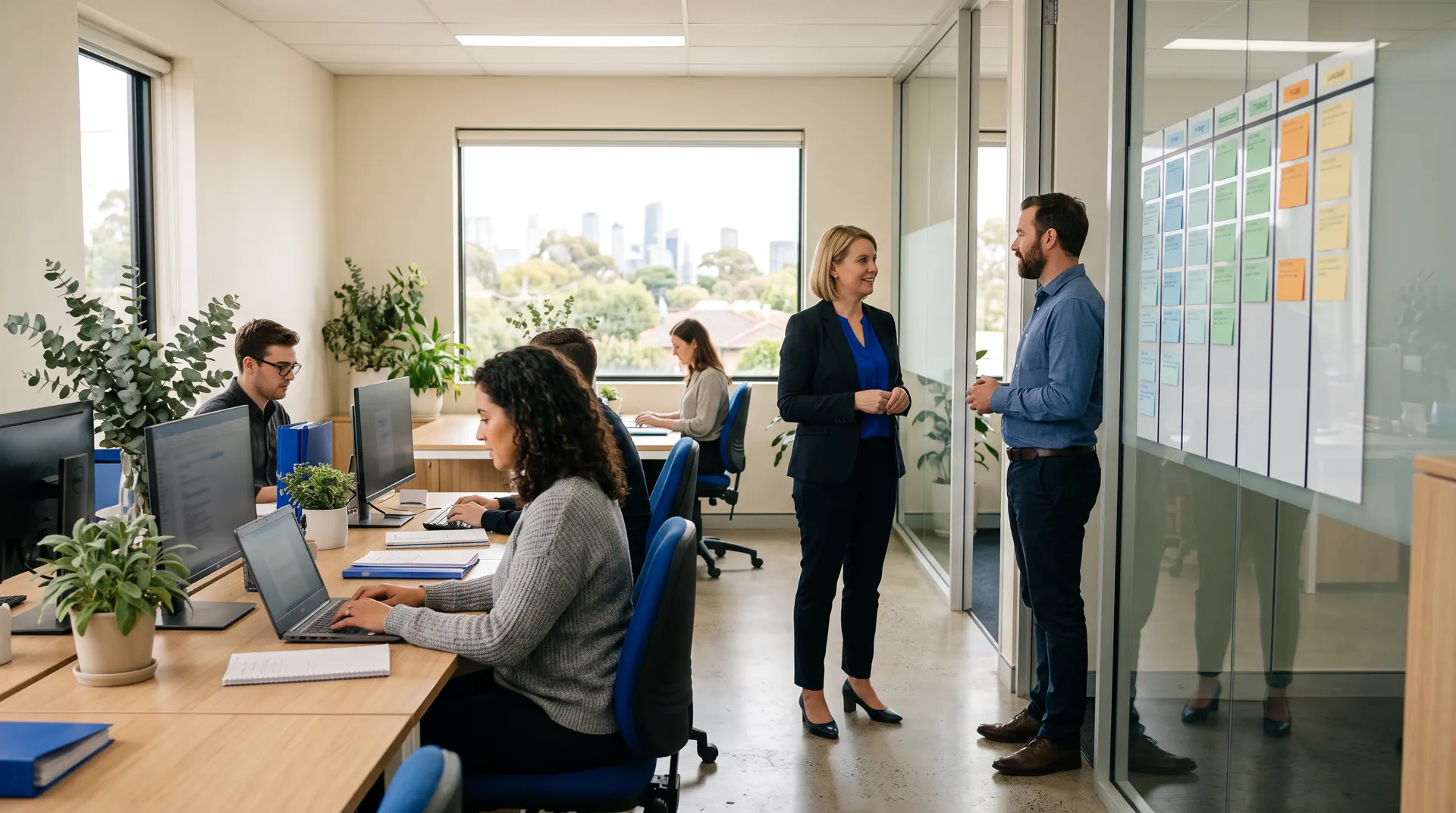 A finance manager talks with a colleague in a bright open-plan office